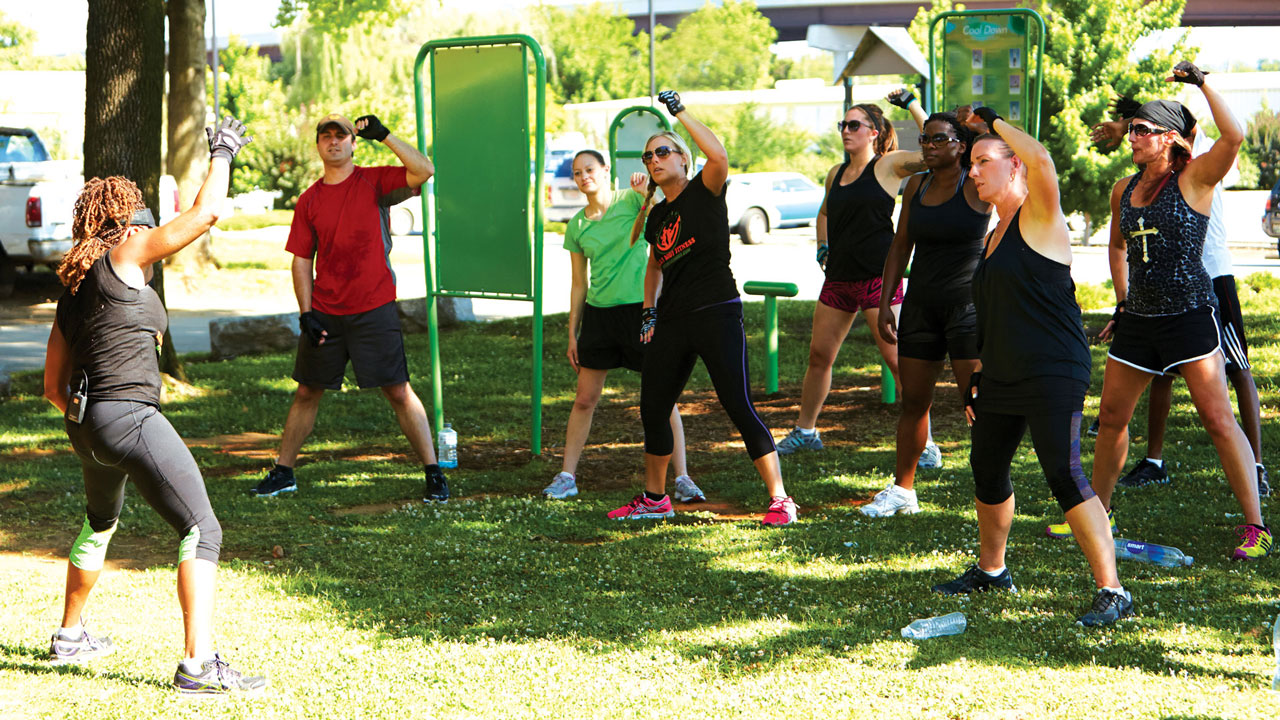 a group exercises together at an outdoor gym